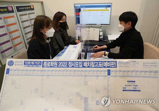 (서울=연합뉴스) 2022학년도 대학수학능력시험 성적표가 통지된 10일 서울 마포구 강북종로학원에서 수험생들이 선생님과 배치표를 살펴보며 상담하고 있다. 2021.12.10