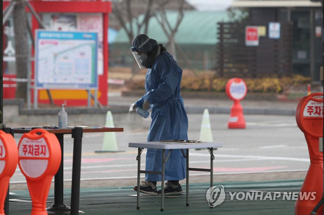 (함평=연합뉴스) 정회성 기자 = 12일 오전 전남 함평군 함평읍 함평엑스포공원 주차장에 마련된 임시 선별진료소에서 방역 공무원이 소독약을 뿌리고 있다. 함평군은 지역 내에서 오미크론 변이 의심 확진자가 10여 명 발생하자 연쇄(n차) 접촉자들의 전수검사를 위해 임시 선별진료소를 운영했다. 2021.12.12