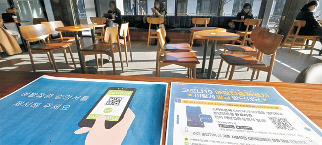 방역 패스 위반 시 과태료 부과 조치가 전면 시행된 13일 오전 서울 송파구의 한 커피전문점 매장 입구에 “예방접종증명서를 제시해 주세요”라는 문구가 적힌 안내문이 붙어 있다.