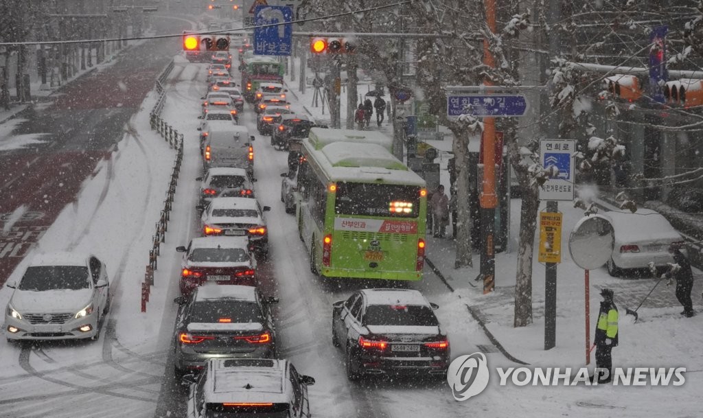 (서울=연합뉴스) 서울을 비롯한 수도권에 올겨울 첫 대설주의보가 내려진 18일 오후 서울 서대문구 연희동 부근 도로에서 차량 정체가 되고 있다. 2021.12.18