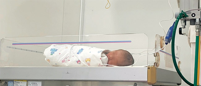 지난 18일 경기 양주소방서 119구급차에서 세상으로 나온 장모(34) 씨 부부의 아기 ‘민초’(민트초코·태명)가 같은 날 서울 중랑구 서울의료원 응급실에 누워 있다. 엄마·아빠의 확진 속에서 민초는 20일 오전 기적처럼 음성 판정을 통보받았다.  장모 씨 제공