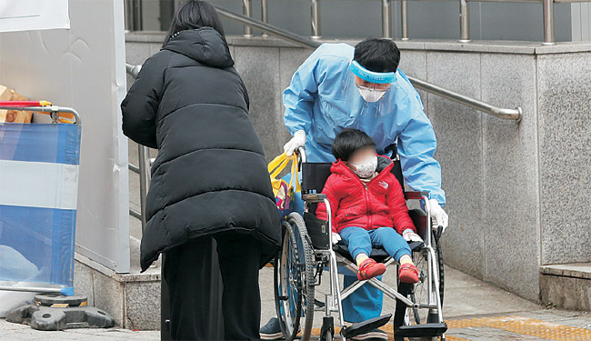 21일 코로나19 위중증 환자가 1022명을 기록해 의료 현장의 과부하가 계속되고 있는 가운데 전날 서울 종로구 서울대병원 의료진이 확진 어린이를 음성 판정 보호자와 함께 중환자실로 이송하고 있다.  뉴시스