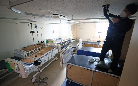 오미크론 대확산 상황에 대비해 비상계획이 발표된 22일 오전 코로나19 거점전담병원으로 지정된 서울 광진구 혜민병원에서 공사 관계자가 중환자실을 음압병동으로 바꾸는 작업을 하고 있다.  연합뉴스