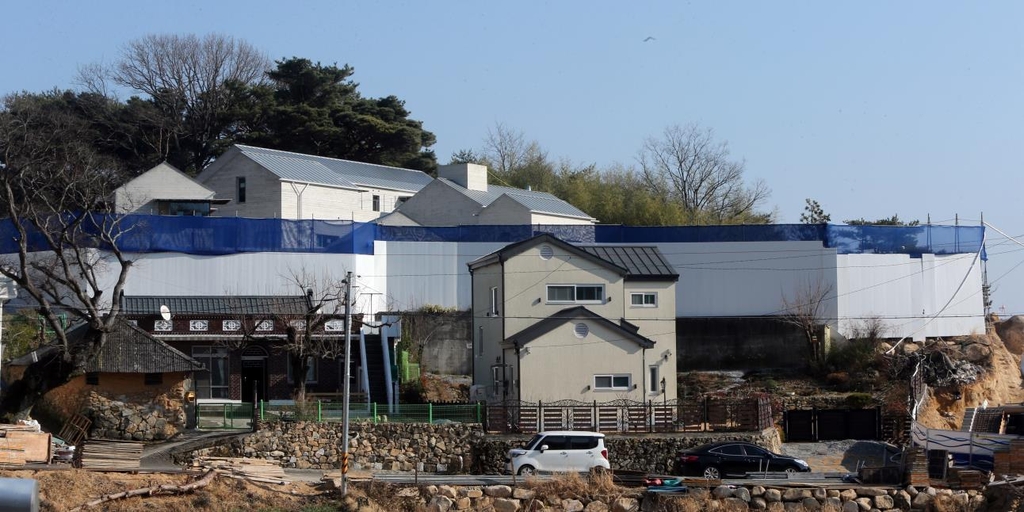 (양산=연합뉴스) 문재인 대통령 내외가 내년 5월 퇴임 후 거주할 경남 양산시 하북면 평산마을 사저 전경. 외관 공사가 마무리되면서 건물 형태가 공사 가림막 너머 보이기 시작했다. 가림막 앞 건물은 타인 소유 건물. 2021.12.22