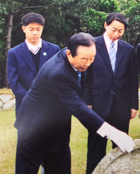 김영삼(가운데) 전 대통령이 지난 2001년 자신의 고향이자 부모의 선산이 있는 경남 거제시를 찾아 어머니의 산소를 어루만지고 있다. 김 전 대통령 뒤 오른쪽에는 차남 김현철 김영삼민주센터 상임이사와 그의 아들 김인규(당시 중학생) 씨가 서 있다.  김인규 제공