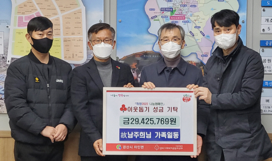 지난 20일 경북 경산시 자인면행정복지센터(면장 최순환·왼쪽 두 번째)에서 정태수(오른쪽 두 번째) 씨 가족이 돌아가신 어머니 남주희 씨 이름으로 이웃돕기 성금을 기탁한 뒤 사진을 촬영하고 있다.  경산시청 제공