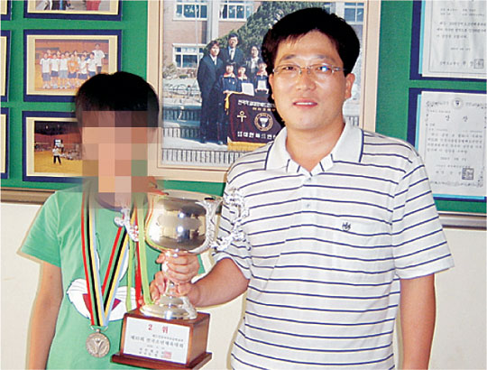 지난 2006년 8월 강원 원주시 남원주초등학교에서 배드민턴 대회 개인전 입상을 한 학생 선수와 기념촬영을 하고 있는 있는 권영남(오른쪽) 교사의 모습.  초록우산어린이재단 제공