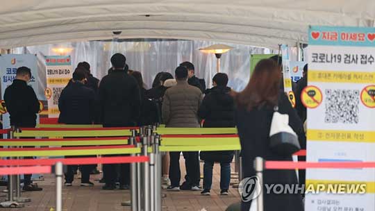 (서울=연합뉴스) 29일 오전 서울 중구 서울시청 앞에 마련된 임시선별진료소에서 시민들이 코로나19 검사를 받기 위해 줄을 서있다.2021.12.29