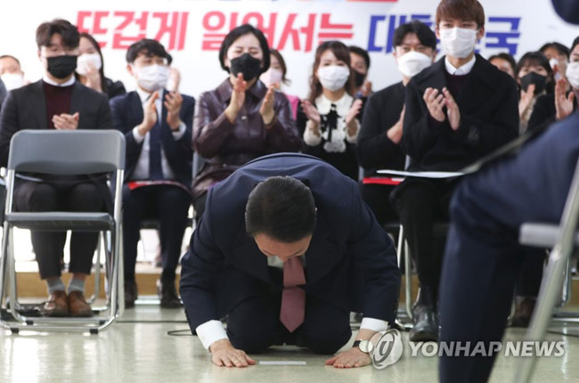 (서울=연합뉴스) 이정훈 기자 = 국민의힘 윤석열 대선 후보가 1일 오후 서울 여의도 대하빌딩에서 열린 선대위 신년인사회에서 구두를 벗고 큰절을 하고 있다. 2022.1.1 [공동취재]