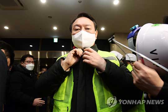 (인천=연합뉴스) 국민의힘 윤석열 대선 후보가 새해 첫날인 1일 0시 대외 교역 최전선인 인천신항 선광신컨테이너터미널(SNCT)을 찾아 현장을 둘러보기에 앞서 형광 안전조끼를 입고 있다. 2022.1.1 [공동취재]