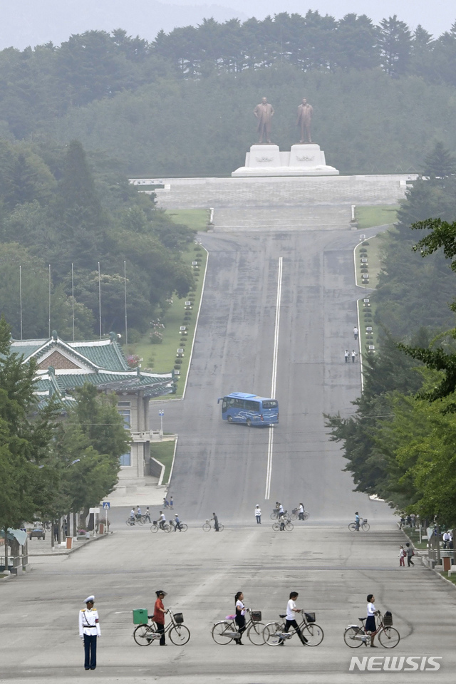 [개성=AP/뉴시스]김정은 북한 국무위원장이 개성에서 신종 코로나바이러스 감염증(코로나19)에 걸린 것으로 의심되는 탈북자가 월북하면서 개성시를 전면 봉쇄했다고 북한 관영매체가 26일 보도했다. 앞서 조선중앙통신은 “3년 전 탈북했던 한 주민이 코로나19에 걸린 채 지난 19일 북한으로 귀향하는 비상사건이 발생하였다”라고 전했다. 사진은 지난 23일 북한 개성에서 주민들이 길을 건너는 모습. 2020.07.26.