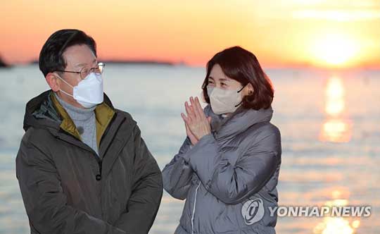 (부산=연합뉴스) 더불어민주당 이재명 대선후보가 부산경남 방문 이틀째인 2일 부산시 사하구 다대포해수욕장에서 부인 김혜경 씨와 함께 ‘2022 글로벌 해돋이 : 지구 한 바퀴’ 온라인 해맞이 행사에서 떠오르는 태양을 배경으로 박수치고 있다. 2022.1.2