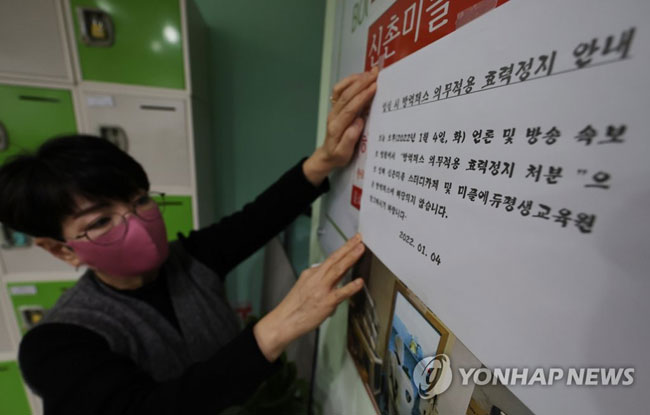(서울=연합뉴스) 박동주 기자 = 4일 오후 서울 서대문구 신촌 한 스터디카페에서 관계자가 ‘방역패스 적용 중단’ 안내문을 붙이고 있다. 이날 서울행정법원 행정8부(이종환 부장판사)는 4일 함께하는사교육연합·전국학부모단체연합 등이 보건복지부 장관을 상대로 낸 집행정지(효력정지) 신청을 일부 받아들였다. 2022.1.4