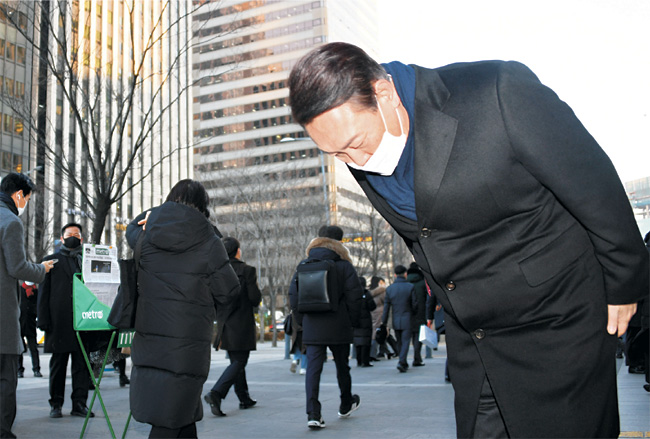 윤석열 국민의힘 대선후보가 6일 오전 서울 영등포구 여의도역 5번 출구에서 출근하는 시민들을 향해 허리를 굽혀 인사하고 있다.  국회사진기자단