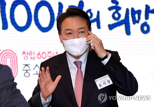 (서울=연합뉴스) 국민의힘 윤석열 대선 후보가 5일 서울 여의도 중소기업중앙회관에서 열린 2022 중소기업인 신년인사회에서 휴대전화로 통화를 하고 있다. 2022.1.5 [국회사진기자단]