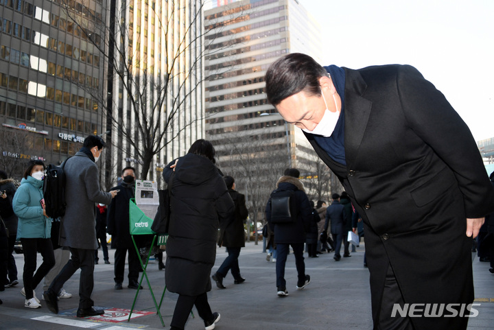 [서울=뉴시스] 국회사진기자단 = 윤석열 국민의힘 대선 후보가 6일 서울 여의도역 출구에서 출근하는 시민들에게 인사하고 있다. 2022.01.06.