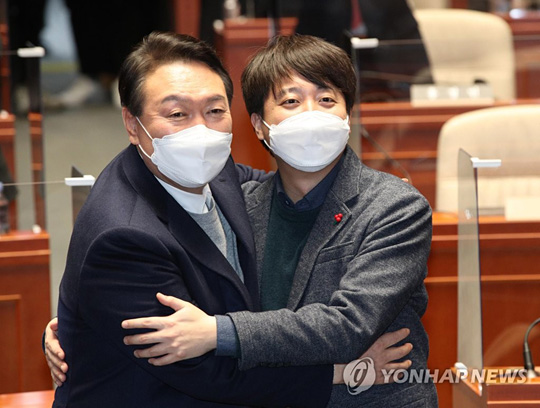(서울=연합뉴스) 극한 대치 끝에 전격 화해한 국민의힘 윤석열 대선 후보와 이준석 대표가 6일 저녁 국회에서 열린 의원총회에서 손을 맞잡고 있다. 2022.1.6 [국회사진기지단]
