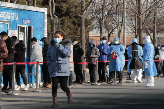 중국 수도 베이징의 상디 지역에 마련된 코로나19 검사소 앞에서 16일 중국인들이 마스크를 착용한 채 줄 서 있다.  EPA 연합뉴스