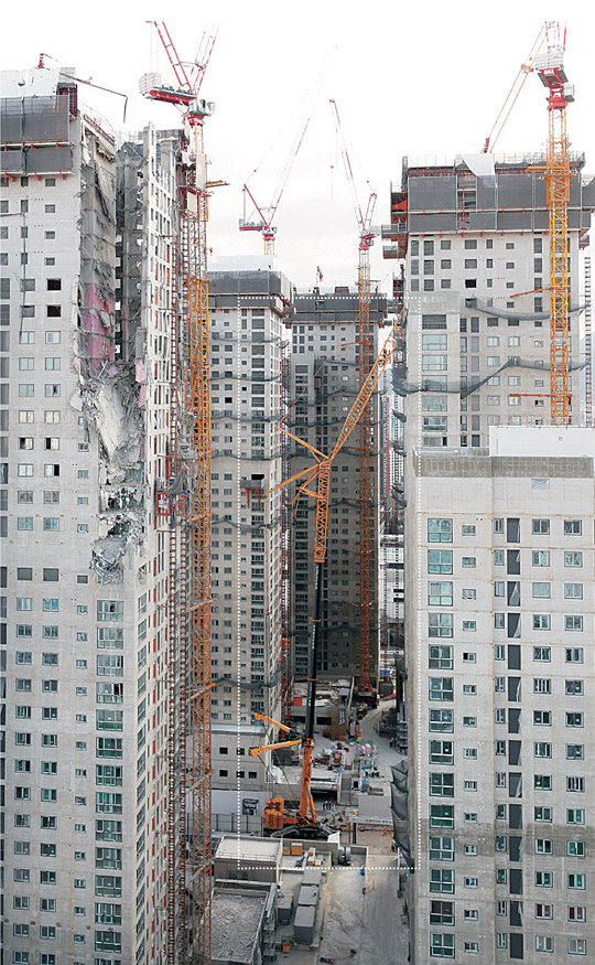 17일 오전 광주 서구 신축아파트 외벽 붕괴사고 현장에 타워크레인을 해체할 크레인(점선)이 설치돼 있다. 약 120m 높이의 해체 크레인은 붕괴 당시 기울어진 타워크레인이 쓰러지지 않도록 보강하는 작업에 투입된다.  연합뉴스