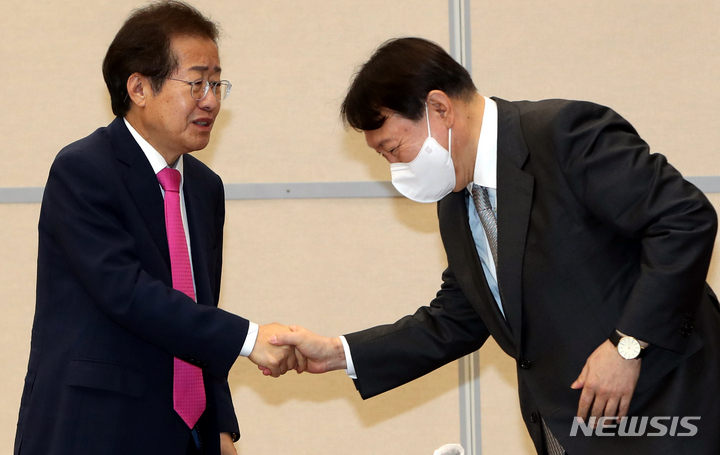 [광주=뉴시스] 11일 오전 광주 서구 김대중컨벤션센터에서 국민의힘 광주 현장 최고위원회의가 열린 가운데 윤석열·홍준표 후보가 악수를 하고 있다. 2021.10.11.