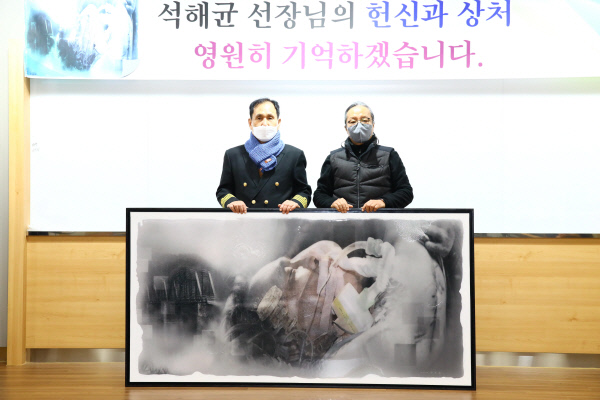 ‘아덴만의 영웅’ 석해균(왼쪽) 당시 삼호주얼리호 선장이 20일 경북 칠곡군 칠곡호국평화기념관에서 서양화가 곽호철 작가 그린 ‘호국 정신’ 그림을 앞에 두고 기념 사진을 찍고 있다. 칠곡군청 제공