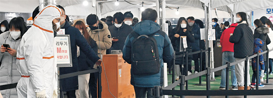 코로나19 진단체계가 일반 감염의심자의 경우, 신속항원검사 위주로 변경되는 방안이 발표된 21일 오전 서울 송파구보건소 선별진료소를 찾은 시민들이 진단검사를 받기 위해 길게 줄을 서서 차례를 기다리고 있다.