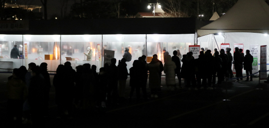 24일 저녁 서울 송파구 잠실종합운동장 제2주차장 임시선별검사소에 밤늦게까지 시민들이 몰리면서 환하게 불이 켜져 있다. 이날 오미크론 변이가 빠르게 확산하면서 25일 코로나19 확진자는 역대 최다인 8571명을 기록했다.   뉴시스