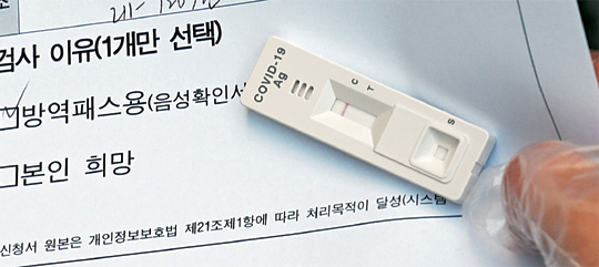 3일 오전 서울 송파보건소 선별진료소에서 신속항원검사를 마친 한 시민이 음성반응이 나온 진단결과를  확인하고 있다.