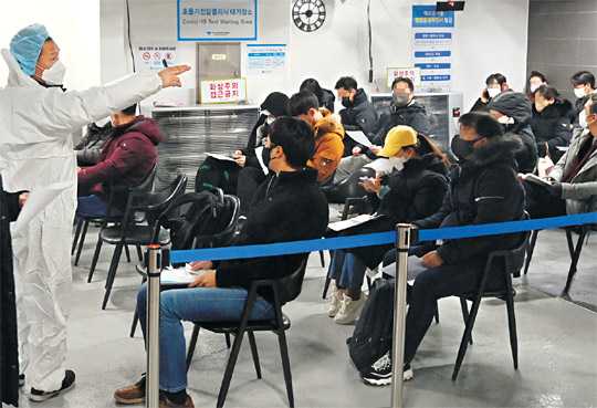 코로나19 동네 병·의원 중심 진료체계 전환 이틀째를 맞은 4일 오전 서울 강남구 역삼동 하나이비인후과 호흡기전담클리닉을 찾은 시민들이 방역복을 착용한 간호사의 안내를 받으면서 신속항원검사를 받기 위해 문진표를 작성하고 있다.  곽성호 기자