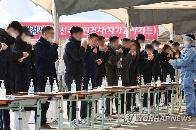 (대전=연합뉴스) 김주형 기자 = 8일 오후 대전 유성구 월드컵경기장에 있는 선별진료소에서 시민들이 자가검사키트를 이용해 신종 코로나바이러스 감염증(코로나19) 신속항원검사를 실시하고 있다. 2022.2.8