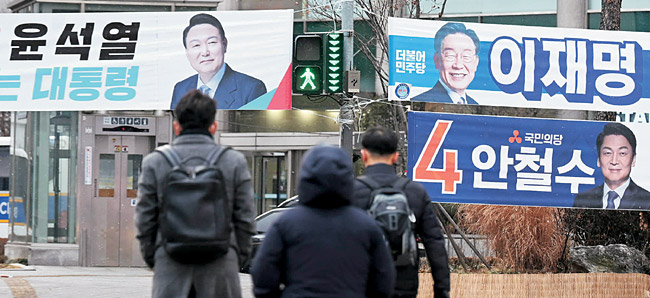 20대 대선 공식선거운동이 시작된 15일 오전 후보 선거 현수막들이 걸린 서울 도심 횡단보도를 유권자들이 건너고 있다. 공식선거운동은 투표일 전날인 3월 8일까지다. 윤성호 기자
