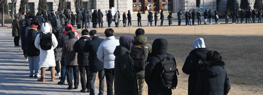 코로나19 오미크론 변이 대폭증으로 하루 신규확진자가 9만443명 발생한 16일 오전 서울시청광장의 임시선별진료소를 찾은 시민들이 영하 10도 안팎의 한파 속에서 유전자증폭(PCR) 검사 등을 받기 위해 길게 줄을 서고 있다. 김호웅 기자