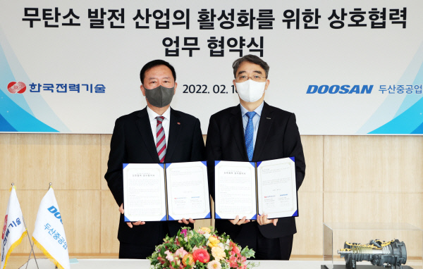 두산중공업 창원 본사에서 16일 열린 협약식에서 김성암(왼쪽) 한국전력기술 사장과 박홍욱 두산중공업 파워서비스 BG장이 협약서에 서명 후 기념촬영을 하고 있다. 두산중공업 제공