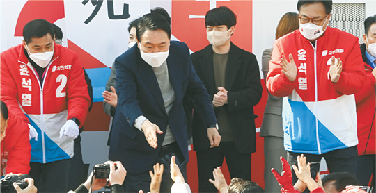 윤석열(단상 왼쪽  두 번째) 국민의힘 대선 후보가 3일 오전 충남 아산 온양온천역 광장 유세에서 지지자들 손을 잡으며 한 표를 호소하고 있다.