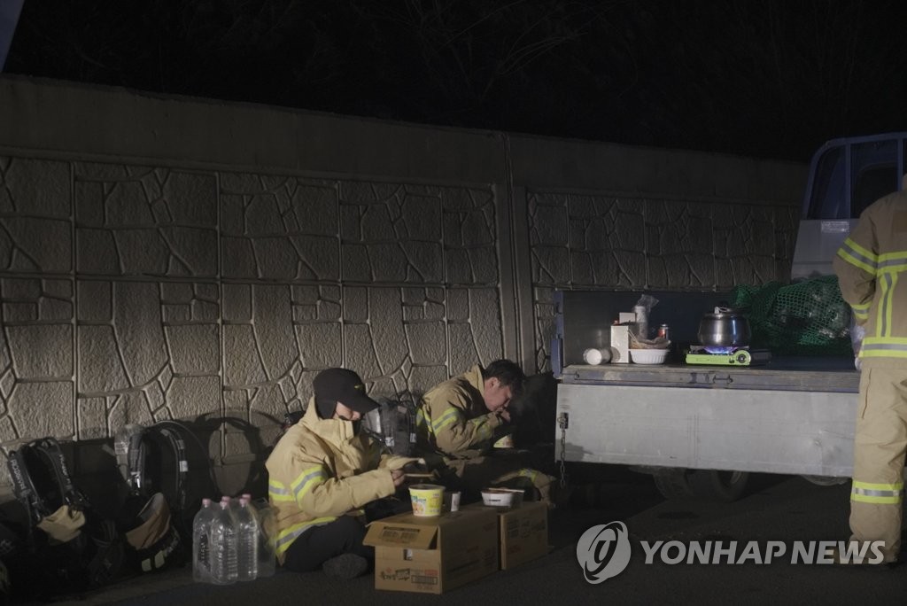 (울진=연합뉴스) 울진·삼척산불 나흘째인 지난 7일 늦은 밤 경북 울진군 북면 나곡리 쓰레기 매립장에서 소방대원들이 진화 작업을 하다 잠시 쉬고 있다. 2022.3.8 [경북소방본부 제공. 재판매 및 DB 금지]