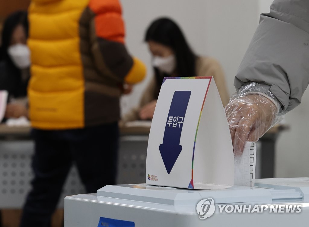 (서울=연합뉴스) 제20대 대통령선거 투표일인 9일 오전 서울 송파구 석촌동 주민센터에 마련된 석촌동 제1투표소에서 비닐장갑을 낀 유권자가 투표용지를 투표함에 넣고 있다. 2022.3.9