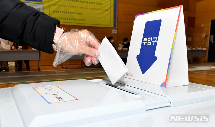 [광주=뉴시스] 제20대 대통령 선거 투표일인 9일 오전 광주 광산구 첨단다목적체육센터(첨단2동 제10투표소)에서 한 유권자가 기표 용지를 투표함에 넣고 있다. 2022.03.09.