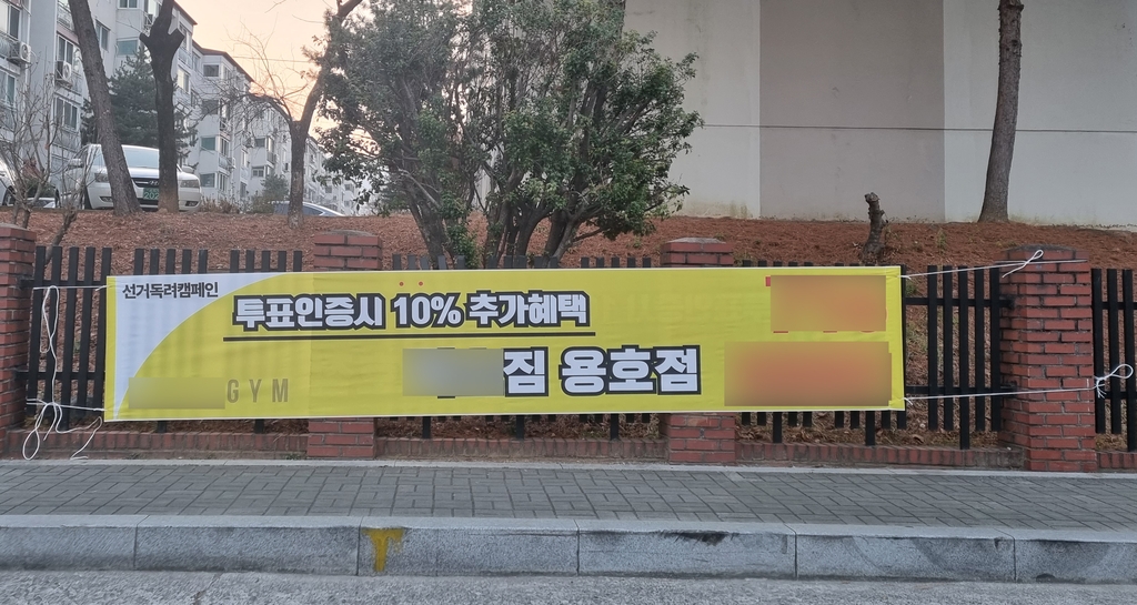 (창원=연합뉴스) 김선경 기자 = 제20대 대통령선거 투표일인 9일 경남 창원시 성산구 용지동 제2투표소가 차려진 용지동행정복지센터 근처에 한 헬스장에서 내건 선거독려 현수막이 붙어 있다.