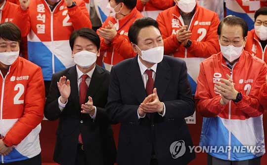 (서울=연합뉴스) 윤석열 제20대 대통령 당선인이 10일 새벽 서울 여의도 국회도서관에 마련된 ‘국민의힘 제 20대 대통령선거 개표상황실’을 찾아 박수를 치고 있다. 왼쪽 두번째는 국민의당 안철수 대표. 2022.3.10 [국회사진기자단]