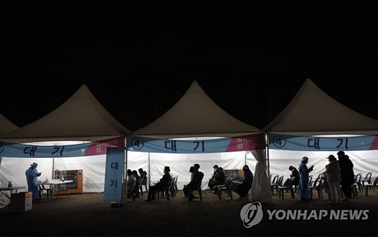 (서울=연합뉴스) 15일 오후 서울 마포구 월드컵공원 평화광장에 마련된 코로나19 임시 선별검사소에서 신속항원검사를 마친 시민들이 검사 결과를 기다리고 있다. 2022.3.15