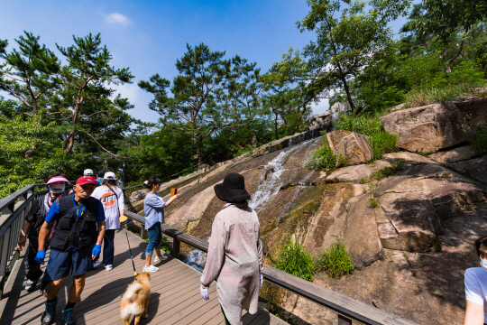 아차산 등산객들이 휠체어와 유모차가 다닐 수 있는 무장애 길인 아차산 동행숲길을 걷고 있다.