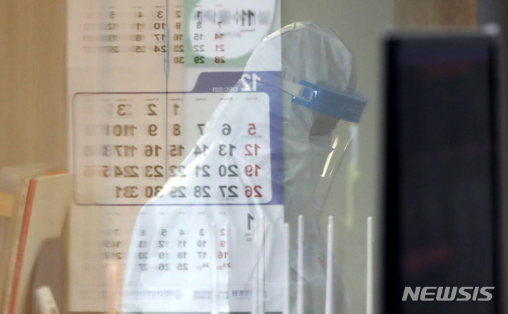 [서울=뉴시스] 22일 오후 코로나19 거점전담병원인 서울 광진구 혜민병원 음압병동에서 업무를 보고 있는 의료진에 달력이 비치고 있다. 2021.12.22.