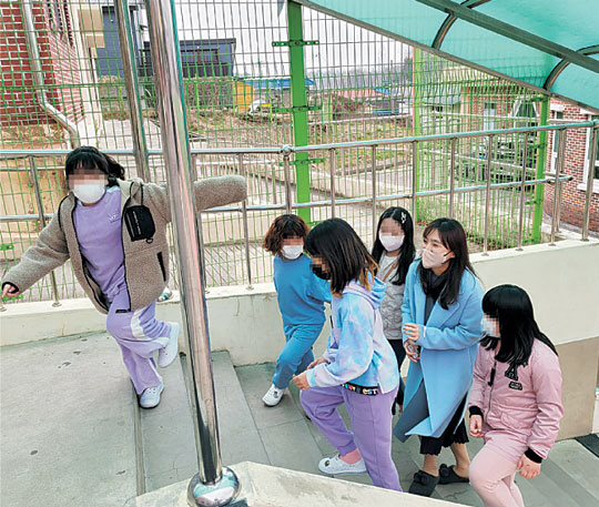 지난 3월 전남 나주시 나주초등학교에서 이은주 교사가 점심 식사 후 학생들과 다정하게 이야기를 나누며 교실로 가는 계단에 오르고 있다. 초록우산어린이재단 제공