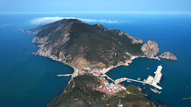 홍도 남쪽의 양산봉 방향에서 바라본 홍도 전경. 가운데 잘록한 부분에 들어선 마을이 여객선이 닿는 홍도 1구 마을이다. 마을 너머로 봉긋하게 솟은 봉우리가 깃대봉이다.