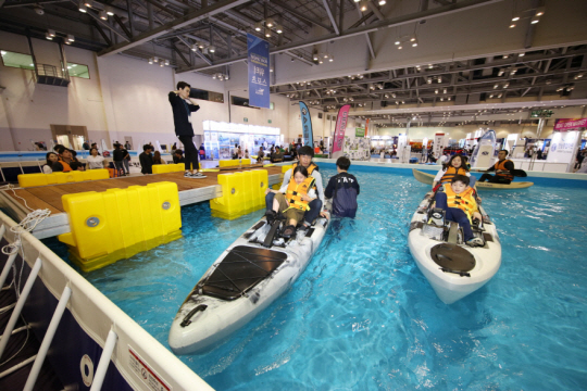 지난 2018년 ‘부산국제보트쇼’ 행사가 열린 부산 해운대 벡스코 내 수조에서 관람객과 어린이들이 해양레저 체험행사를 하고 있다.  부산시 제공