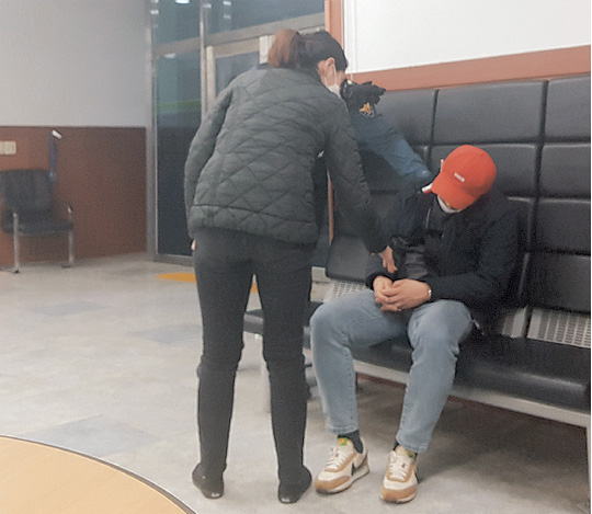 20일 새벽 서울 강남구 역삼지구대에서 경찰 연락을 받고 온 한 여성이 술에 취해 지구대에서 잠이 든 남편을 깨우고 있다.