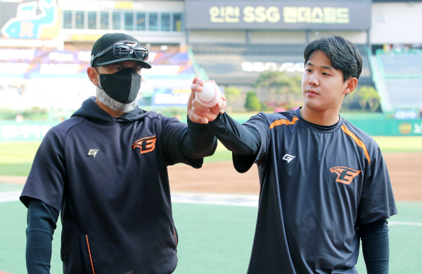 한화의 호세 로사도 투수 코치(왼쪽)가 4일 인천SSG랜더스필드에서 열린 SSG와의 원정경기를 앞두고 윤대경에게 슬라이더 그립에 대해 설명하고 있다.  한화 제공