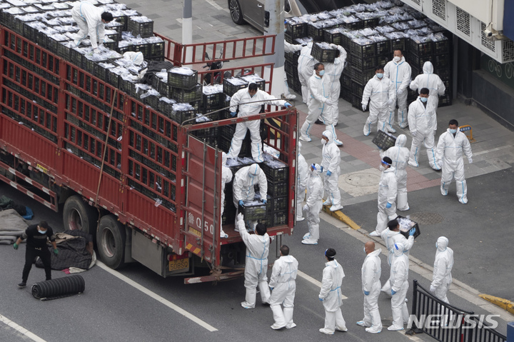 [상하이=AP/뉴시스] 6일 중국 상하이에서 보호복을 착용한 작업자들이 주민들에게 나눠줄 식료품 등을 트럭에서 내리고 있다. 코로나19 급증으로 봉쇄 중인 상하이는 사실상 무기한 전면 봉쇄에 들어갔다. 2022.04.06.