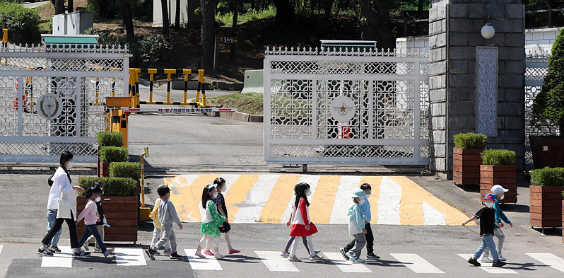 제20대 대통령 취임식을 하루 앞둔 9일 오전 대통령 집무실이 이전하는 서울 용산구 국방부 청사 입구 앞을 어린이들이 지나가고 있다. 뒤쪽으로 국방부, 합동참모본부 현판이 가려져 있다. 뉴시스