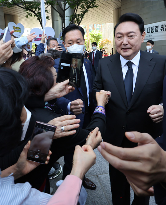 윤석열 대통령이 10일 오전 제20대 대통령 취임식에 참석하기 위해 서울 서초동 자택을 나서며 환영나온 주민들과 주먹인사를 하고 있다.  연합뉴스